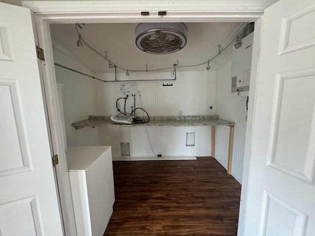 laundry room with water heater and dark wood finished floors