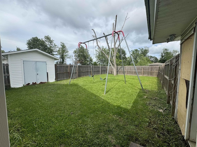 view of yard with a fenced backyard, a storage unit, and an outdoor structure
