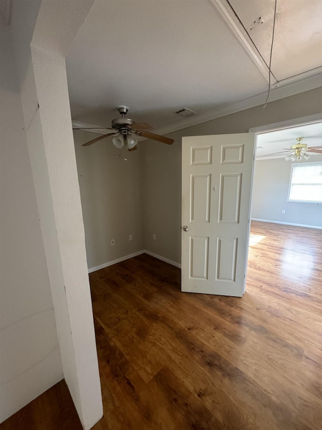 empty room featuring baseboards, attic access, ceiling fan, and wood finished floors