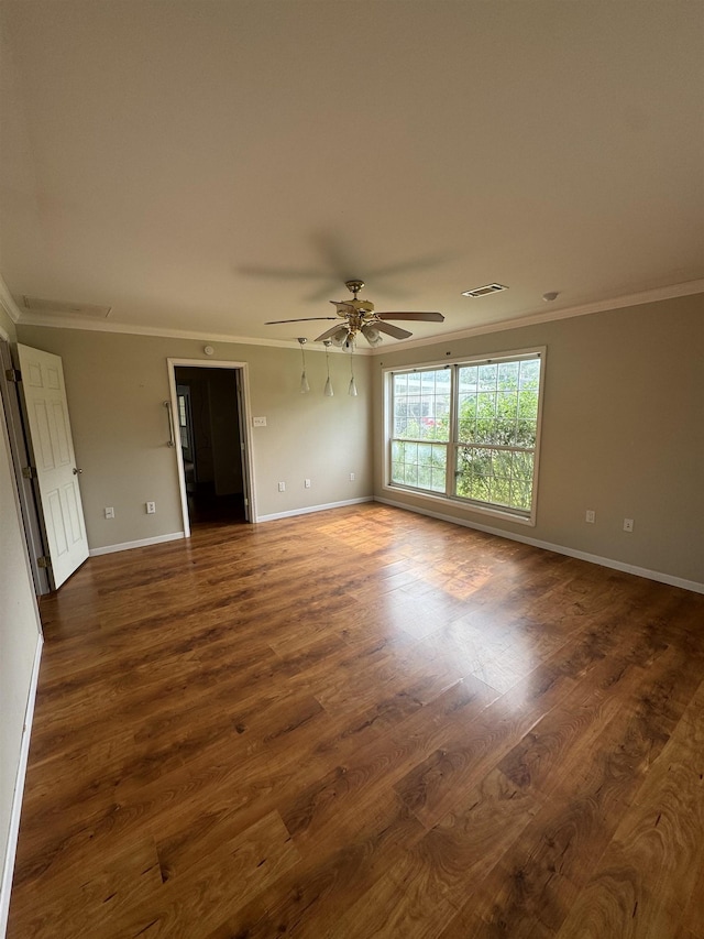 unfurnished room featuring crown molding, baseboards, and dark wood-type flooring