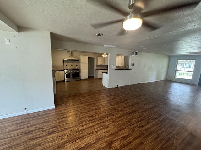 unfurnished living room with visible vents, a ceiling fan, a textured ceiling, and dark wood-style flooring