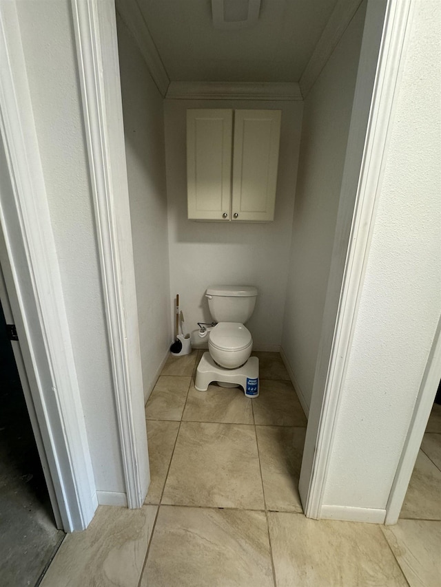 bathroom featuring crown molding, tile patterned flooring, and toilet