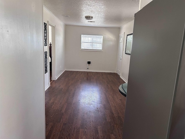 spare room featuring visible vents, baseboards, a textured ceiling, and wood finished floors