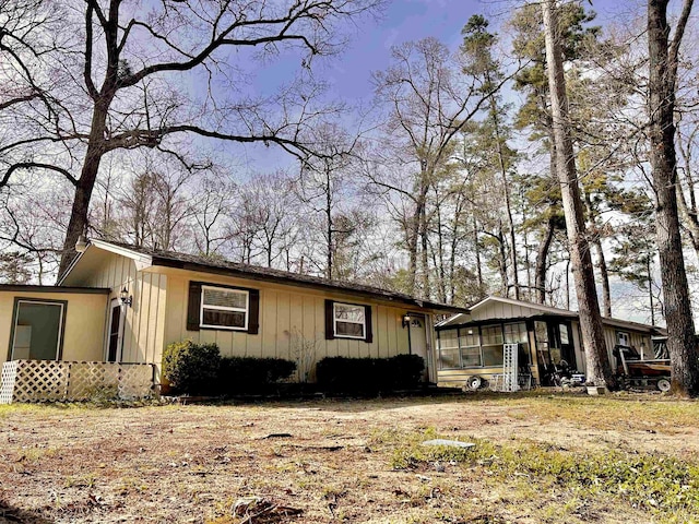 view of front of home featuring board and batten siding and a sunroom