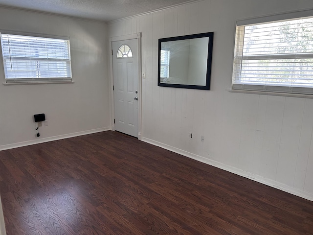 foyer entrance featuring a healthy amount of sunlight, a textured ceiling, and wood finished floors