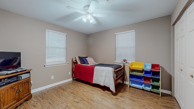 bedroom with ceiling fan, light hardwood / wood-style floors, and a closet