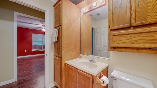 bathroom with hardwood / wood-style flooring, ceiling fan, toilet, and vanity