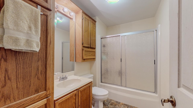 full bathroom featuring vanity, toilet, and combined bath / shower with glass door