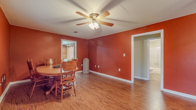 dining space with ceiling fan and light wood-type flooring