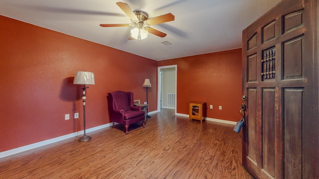 living area featuring hardwood / wood-style floors and ceiling fan