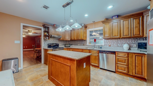 kitchen with ceiling fan, sink, decorative light fixtures, a kitchen island, and appliances with stainless steel finishes