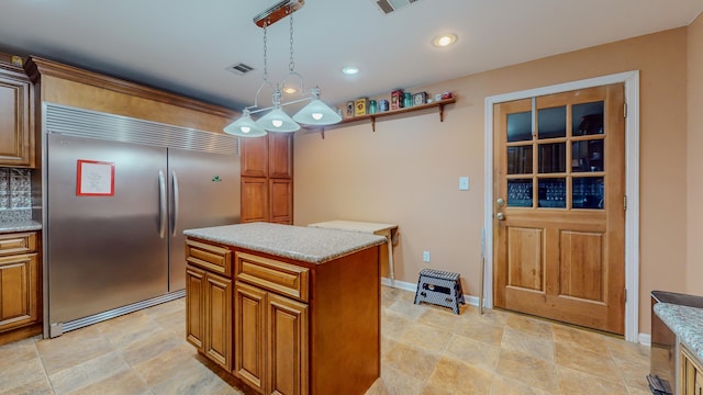 kitchen with backsplash, a kitchen island, pendant lighting, and stainless steel built in refrigerator