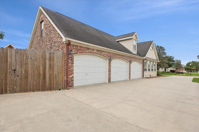 garage with fence and driveway