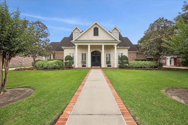 neoclassical / greek revival house with brick siding and a front yard