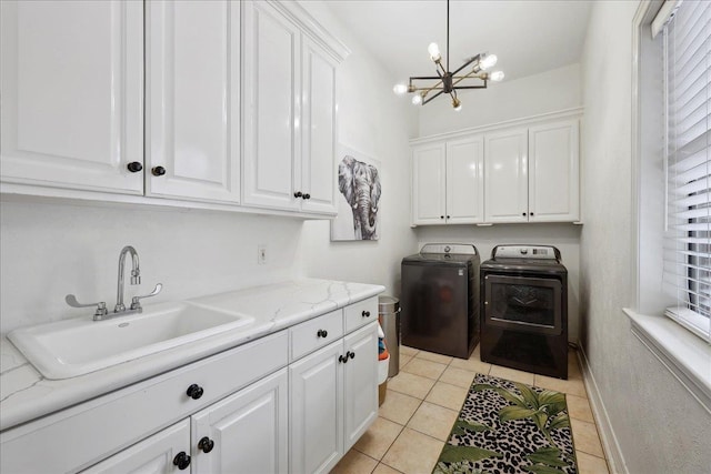laundry room featuring cabinet space, a sink, light tile patterned floors, a notable chandelier, and washer and dryer