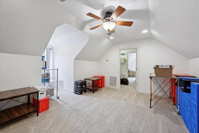 additional living space featuring carpet floors, lofted ceiling, a textured ceiling, and visible vents