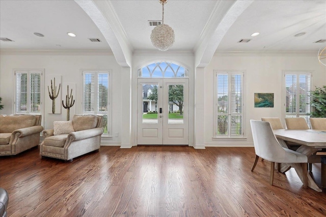 foyer entrance featuring visible vents, ornamental molding, and dark wood finished floors