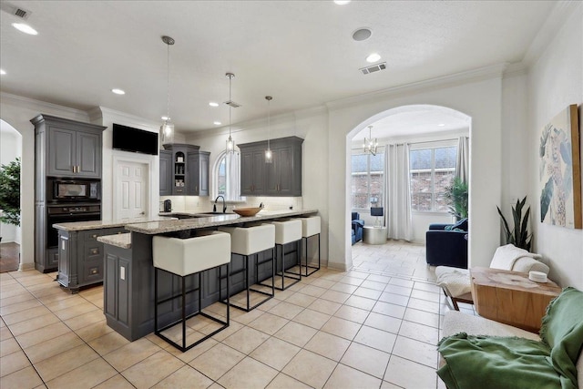 kitchen with arched walkways, visible vents, gray cabinets, and black appliances