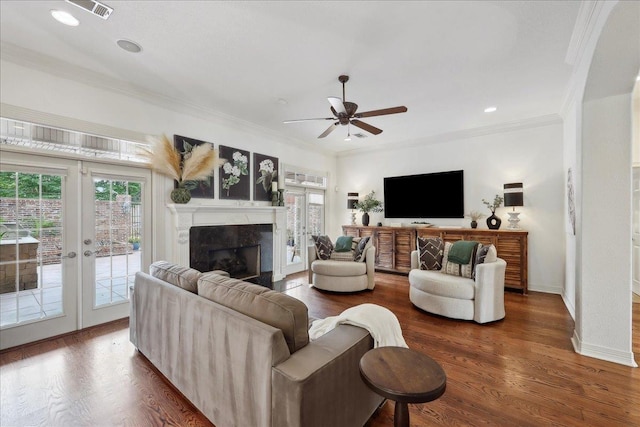 living room featuring a fireplace, ceiling fan, ornamental molding, and wood finished floors