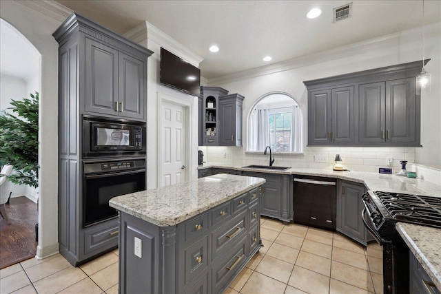 kitchen with gray cabinets, visible vents, a center island, a sink, and black appliances