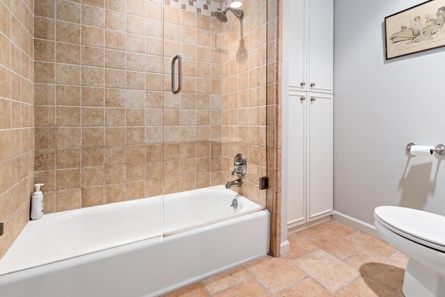 bathroom featuring shower / bath combination with glass door and toilet