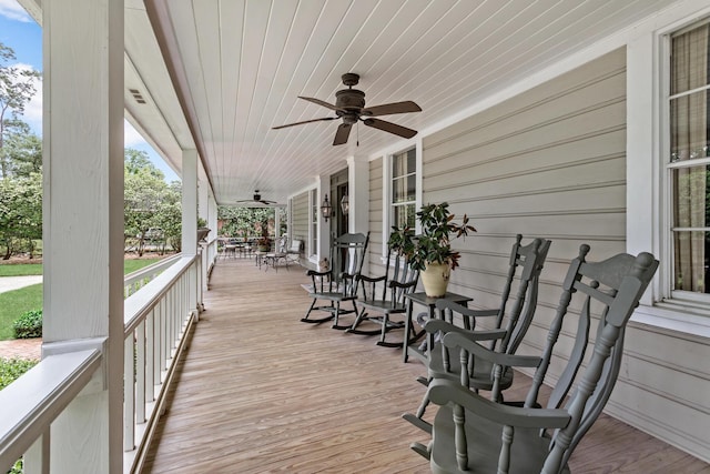 wooden deck featuring covered porch and ceiling fan