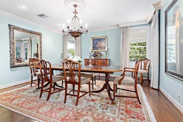 dining room featuring hardwood / wood-style flooring, an inviting chandelier, and crown molding