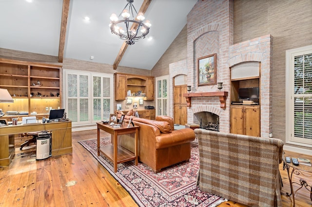 living room with light wood-type flooring, beam ceiling, high vaulted ceiling, a fireplace, and a chandelier