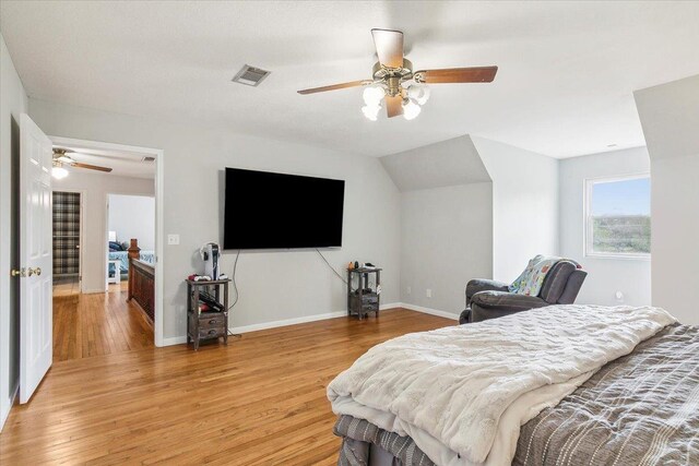 bedroom with vaulted ceiling, light hardwood / wood-style flooring, and ceiling fan