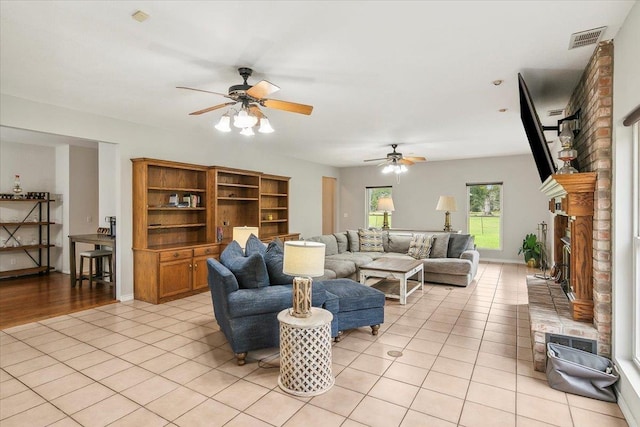 tiled living room with a brick fireplace and ceiling fan