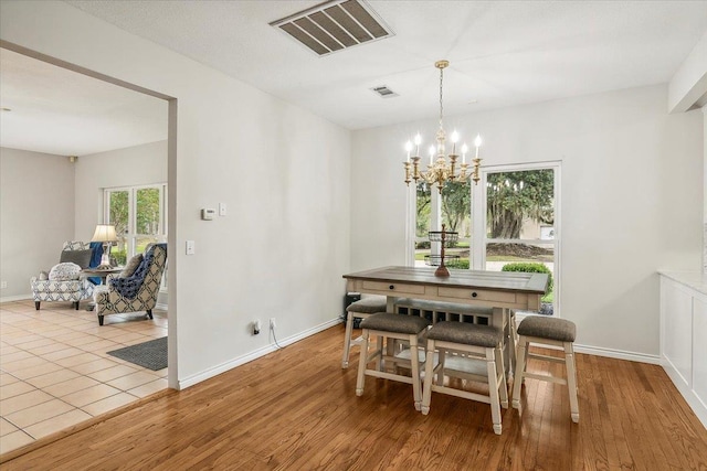 dining area featuring light hardwood / wood-style floors and an inviting chandelier