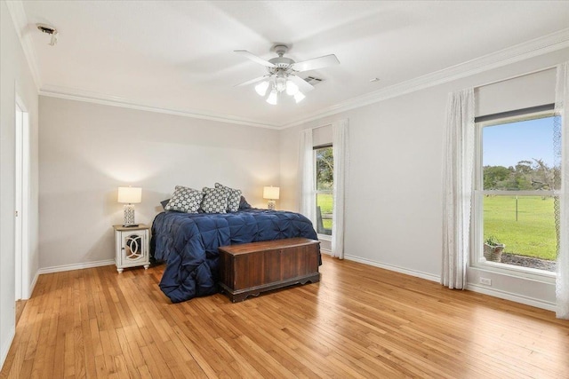 bedroom with multiple windows, ceiling fan, ornamental molding, and light wood-type flooring