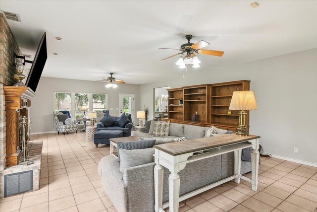 living room with ceiling fan, light tile patterned floors, and a brick fireplace