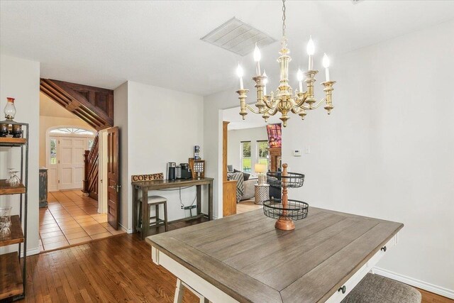 dining area featuring hardwood / wood-style floors and a notable chandelier