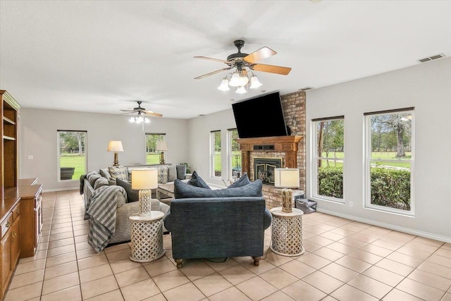 tiled living room featuring ceiling fan and a brick fireplace