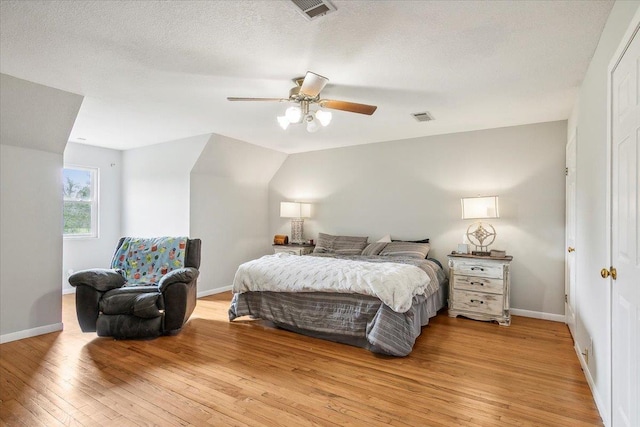 bedroom featuring ceiling fan, a textured ceiling, and light wood-type flooring