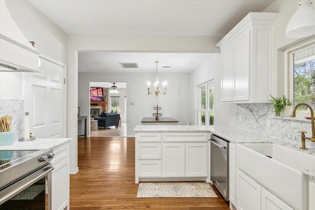 kitchen with hardwood / wood-style floors, backsplash, sink, white cabinetry, and stainless steel appliances