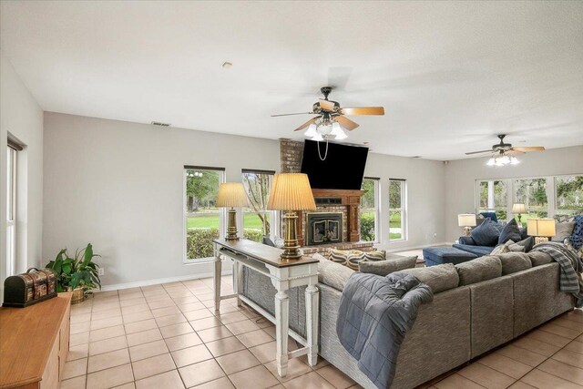 tiled living room with ceiling fan and a healthy amount of sunlight