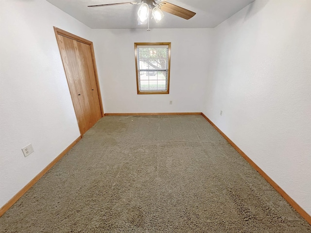 carpeted spare room with ceiling fan