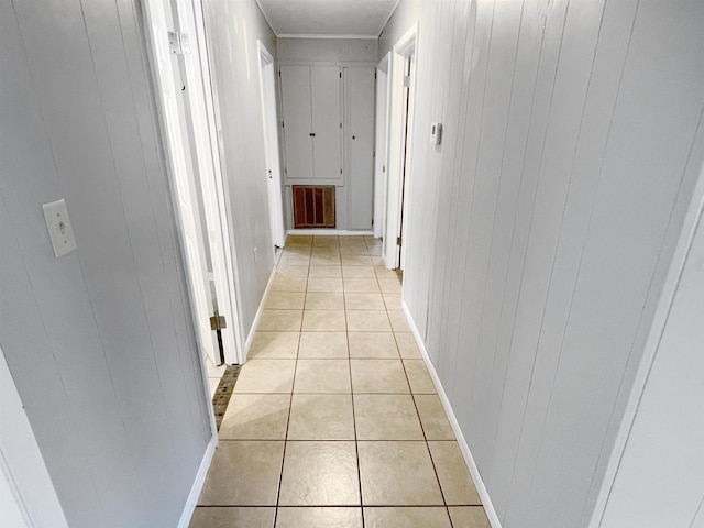 hall with wooden walls and light tile patterned floors