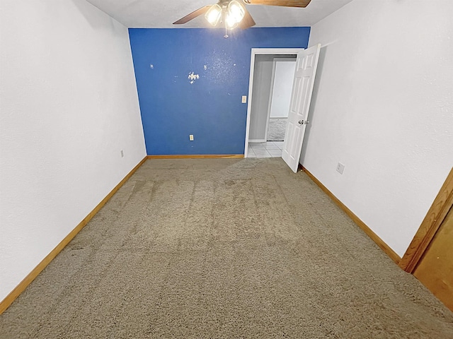 carpeted spare room with ceiling fan