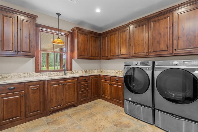 laundry area featuring washer and dryer, cabinets, and sink