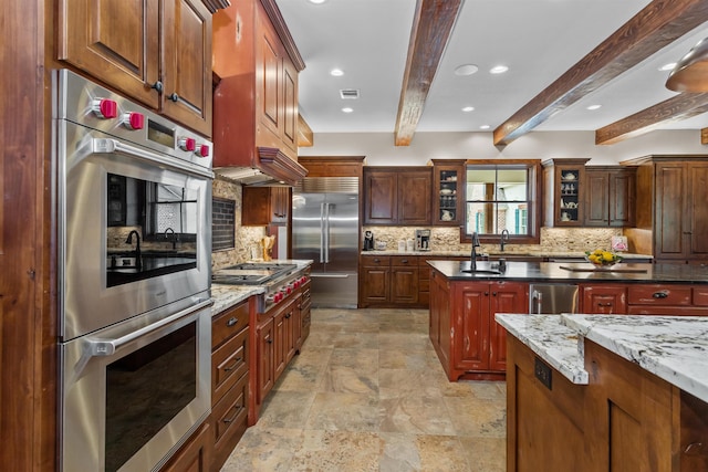 kitchen with backsplash, sink, dark stone countertops, beamed ceiling, and stainless steel appliances