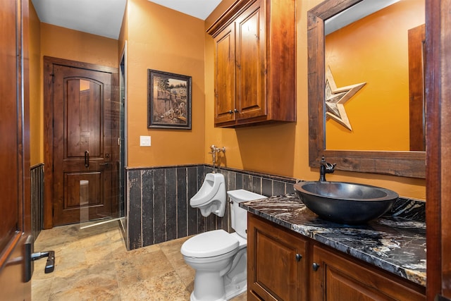 bathroom featuring vanity, toilet, and tile walls