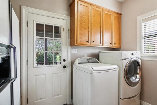 laundry area with washer and dryer and cabinets