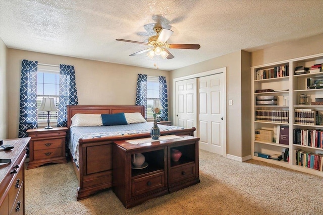 carpeted bedroom featuring multiple windows, ceiling fan, a closet, and a textured ceiling