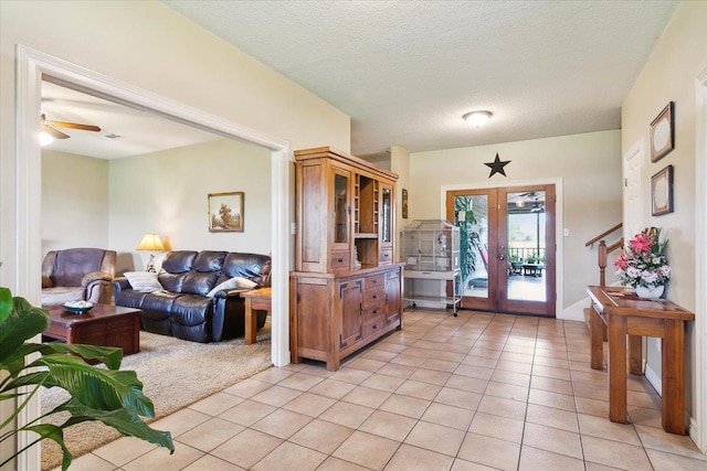 tiled foyer entrance featuring ceiling fan, french doors, and a textured ceiling