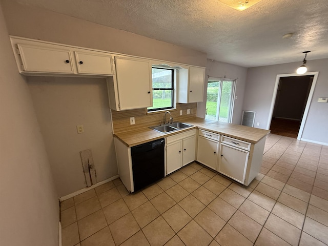 5085 Plant Rd, Beaumont, TX 77708 - kitchen with black dishwasher, a peninsula, light tile patterned flooring, white cabinets, and a textured ceiling