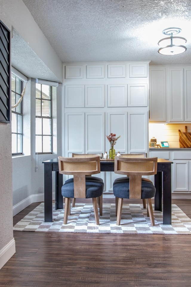 dining space featuring dark hardwood / wood-style floors and a textured ceiling