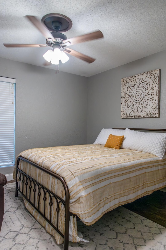 bedroom featuring ceiling fan and a textured ceiling